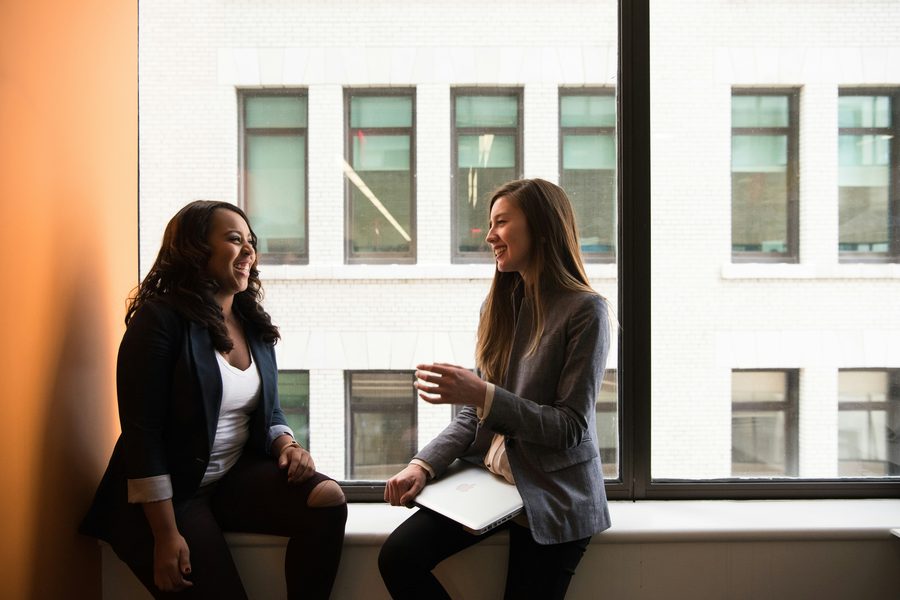Two women in discussion by an office window