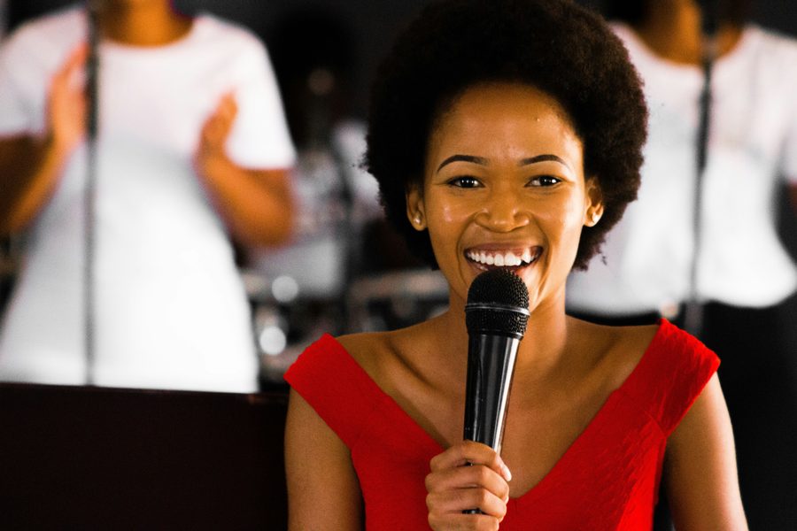 A woman speaking into a microphone, mid-story